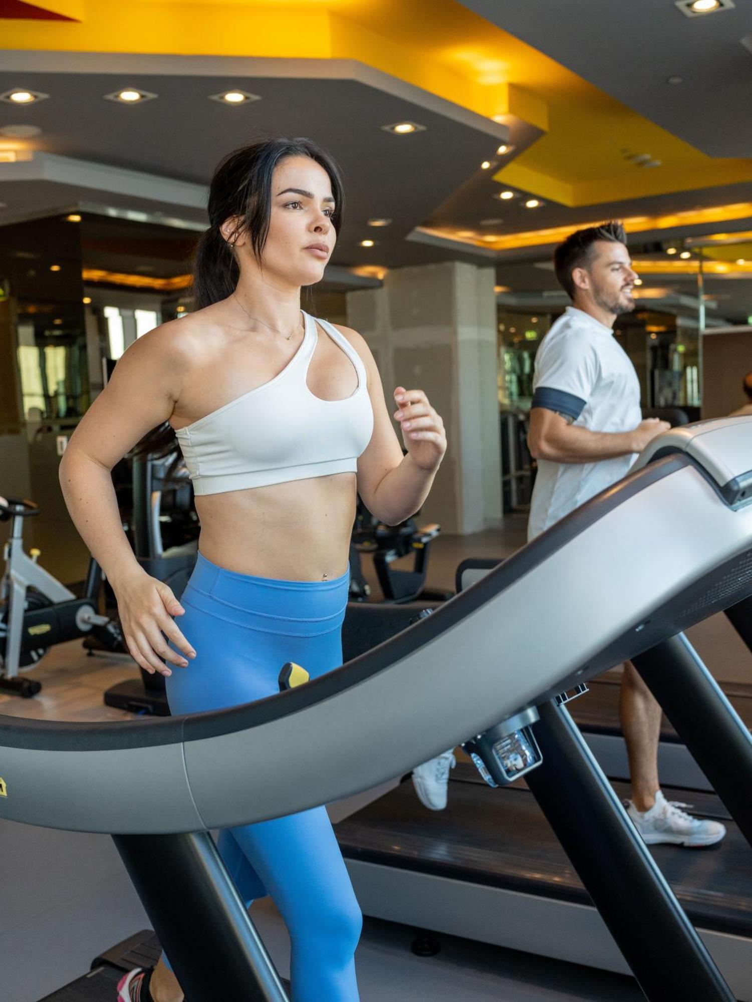 V Hotel Dubai, Curio Collection By Hilton Luaran gambar A woman and a man on a treadmill